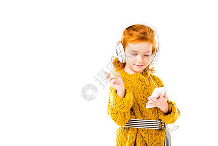 红发孩子听音乐用智能手机图片