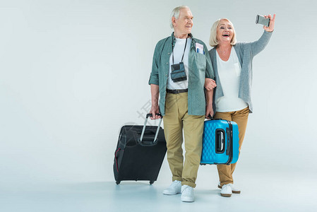 带旅行袋智能手机自拍旅行概念的老夫妇笑图片
