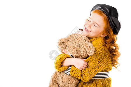 抱着泰迪熊的红发快乐孩子闭着眼睛图片
