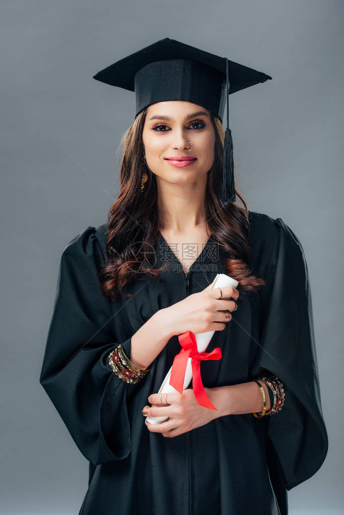 穿着学术礼服和毕业帽的快乐印度女学生拿着文凭