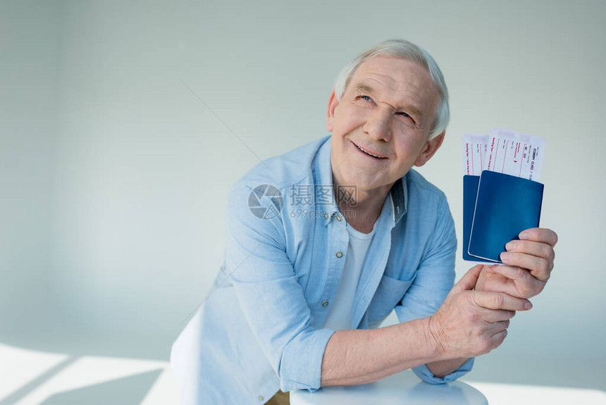 带着护照和机票旅行概念的笑老人肖像画图片