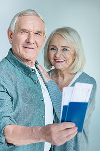 微笑的老人肖像展示护照和门票与妻子相图片