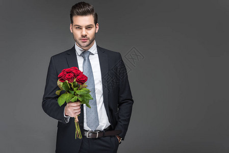 英俊男人拿着红玫瑰花束图片