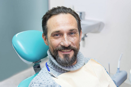 牙科椅子的微笑的人看牙医的人相信专图片