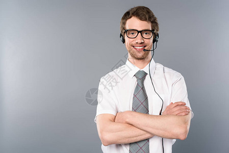 手戴眼镜和头戴耳机的微笑呼叫中心操作员图片