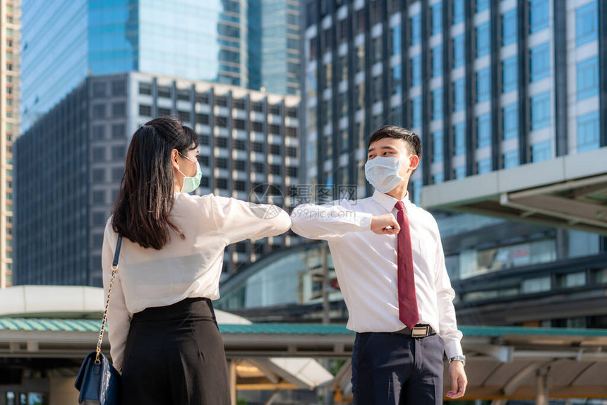 肘部肿块是避免冠状传播的新型问候语两个亚洲商业朋友在办公楼前见面他们没有用或握手打招呼图片