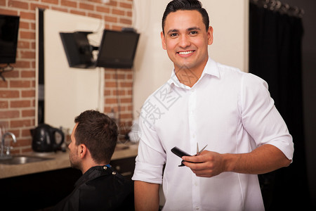 英俊的年轻的拉丁青年理发师爱着他图片