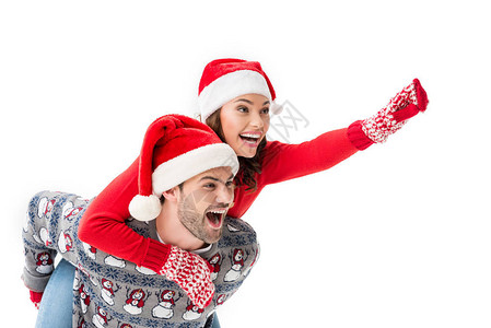 年轻人骑着背圣诞老人帽子的女人指着被白图片