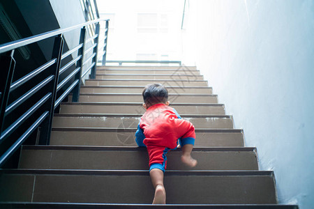 有趣的小男孩爬上楼梯婴儿发图片