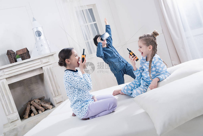 穿着睡衣的可爱小孩玩着对讲机和图片