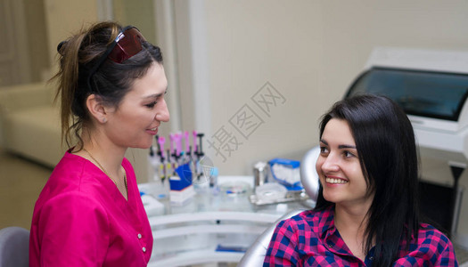 女牙医在办公室里微笑和与女病人交图片