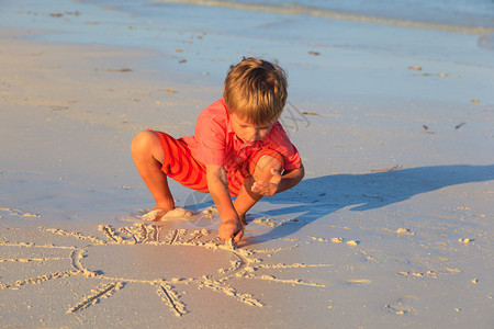 小男孩在沙滩上晒太阳图片