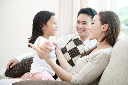在客厅里和女儿玩耍的快乐亚洲家庭图片