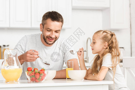 父亲和女儿在厨房吃早餐图片