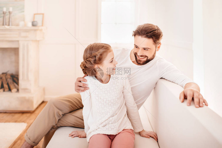 可爱的小女孩和父亲坐在沙发上图片