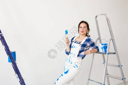 维修翻新家和人的概念年轻女子在白墙上图片