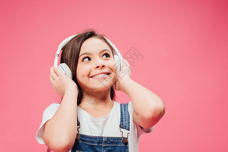 爱听音乐和感动耳机的儿童在粉图片