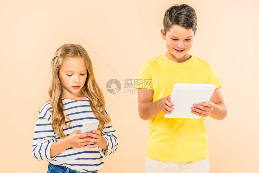 两个孩子使用智能手机和数字平板电脑在图片
