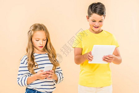 两个孩子使用智能手机和数字平板电脑在图片