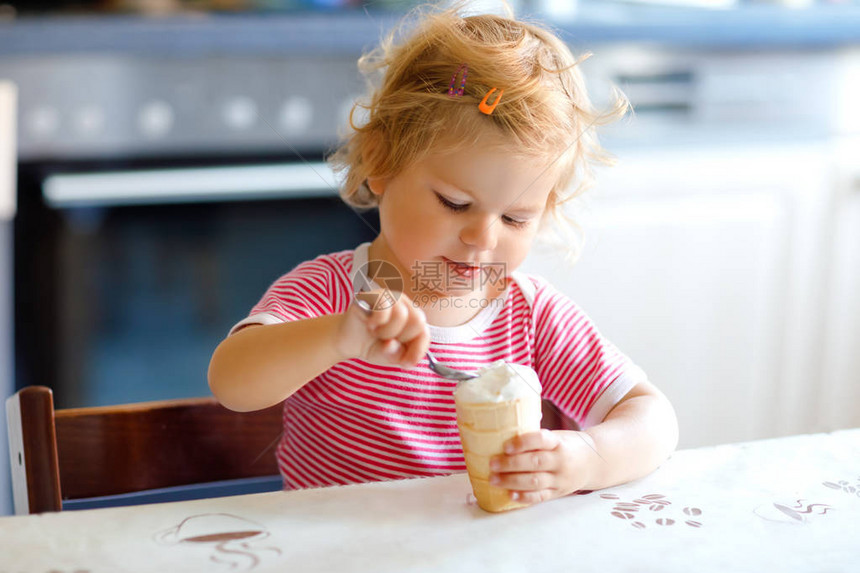 可爱的女婴在华夫饼锥中用勺子甜冰淇淋吃东西食物儿童喂养和发展理念可爱的蹒跚学步的孩子图片