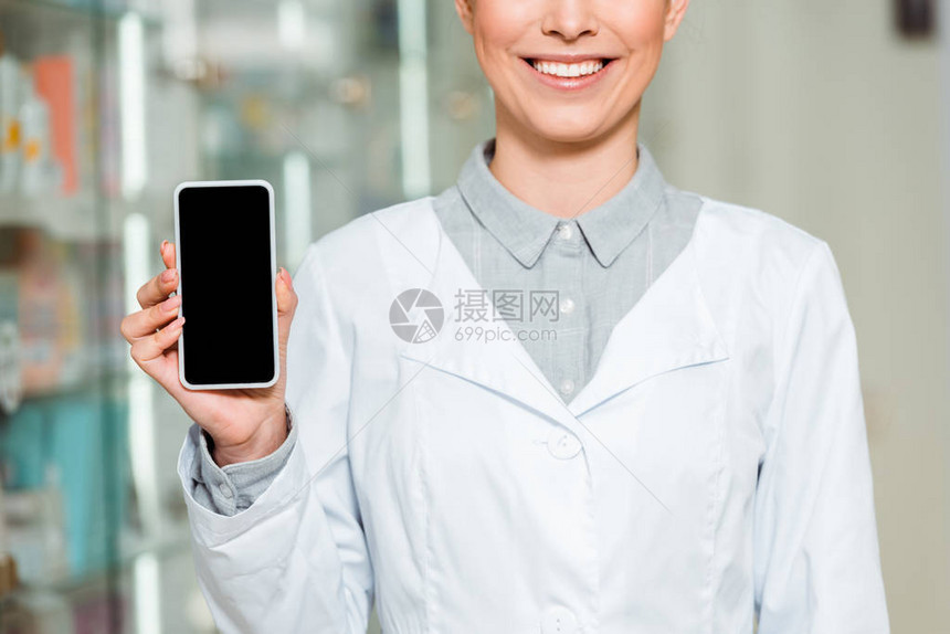 微笑的药剂师用空白屏幕手持智能手图片