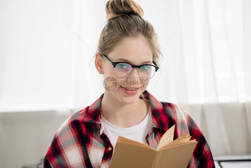 戴眼镜和格衬衫阅读书的图片