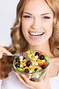 快乐笑的年轻美女的肖像带着健康的素食沙图片
