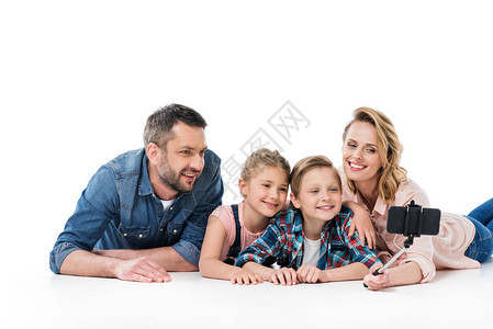 和两个孩子一起玩自拍的快乐家庭与智能手机图片