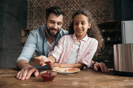 快乐的父亲和女儿在厨房图片