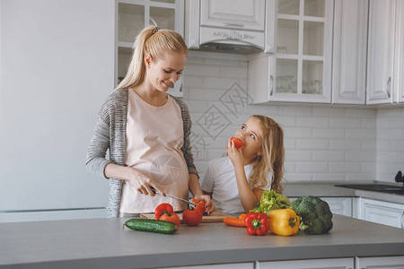 女儿在厨房做饭时吃蔬菜而怀孕母图片