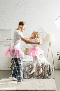 快乐的父亲和可爱的小女儿穿着粉红色的裙图片