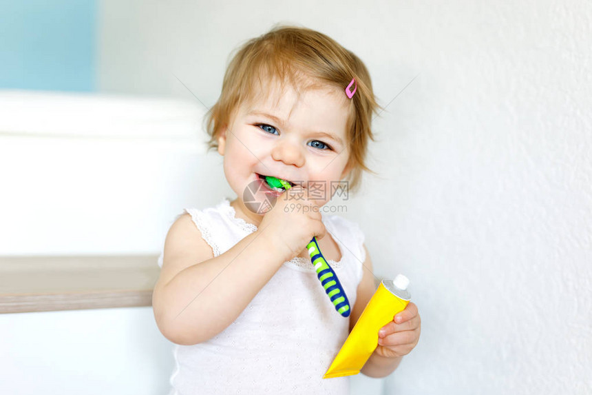 小女婴拿着牙刷和第一次刷牙图片