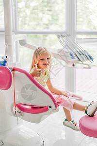 在牙医办公室等牙医时笑着的小孩大图片