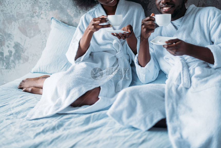 年轻非裔美夫妇在床上喝咖图片