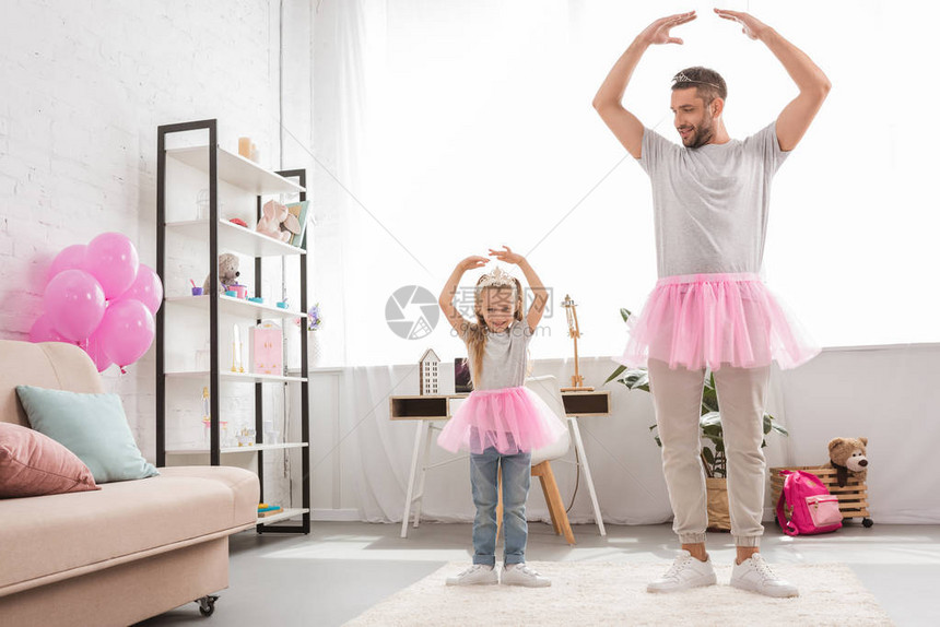 父亲和女儿穿粉红色的裙跳图片