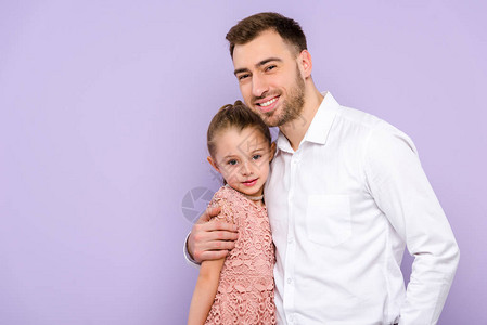 父亲拥抱的拥抱女儿在紫图片