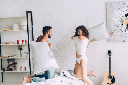 快乐的一对年轻幸福的情侣在家卧室枕图片