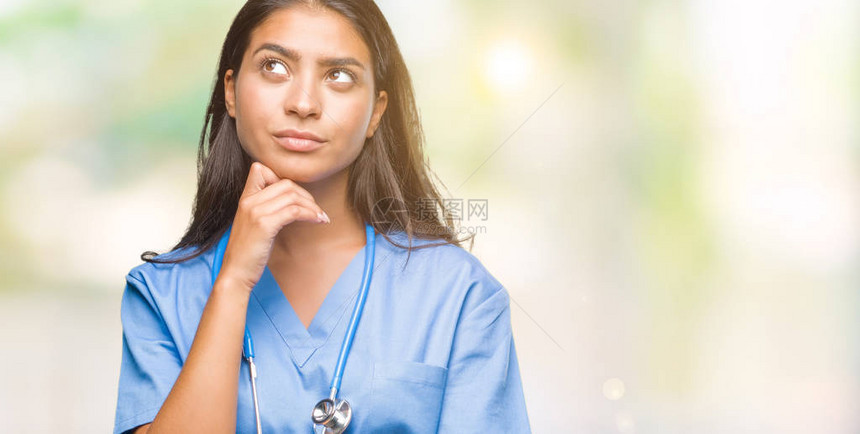 年轻的阿拉伯医生外科医生女人在孤立的背景下用手托着下巴思考问题图片
