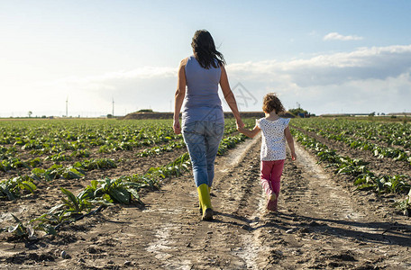 农妇和小女孩在农田上行走图片