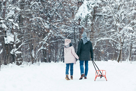 在雪地公园行走时手牵的滑雪鞋搭起手的一对图片