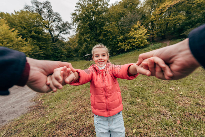 父亲和女儿握手在秋天公园玩得开图片