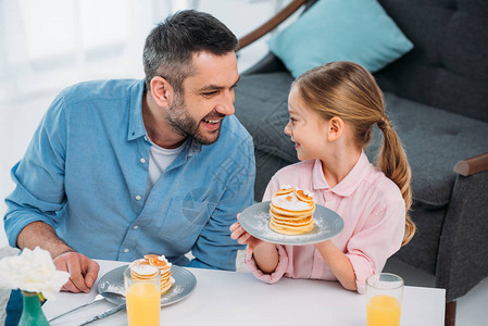 快乐的父亲和小女儿在家吃早饭图片