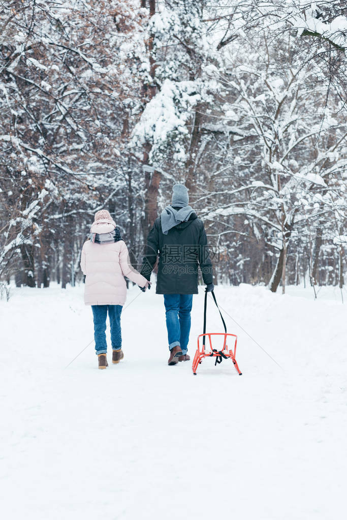 在雪地公园行走时手牵的滑雪鞋搭起手的一对图片