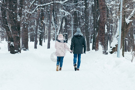 情侣牵手在冬季公园散步的背影图片