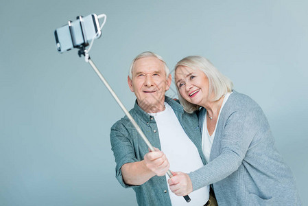 笑的老夫妇情侣用智能手机在灰图片