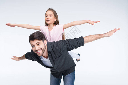 快乐的父亲搭载着小女儿的快乐父亲带着张开的双臂图片