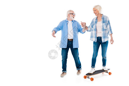 快乐的老年情侣滑板和握手在图片