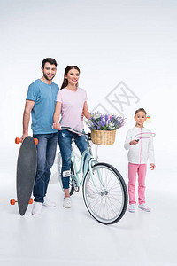 带着滑板和自行车的笑着家庭在图片