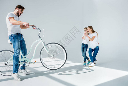 笑着妈和女儿看着情绪激动的男人玩骑图片