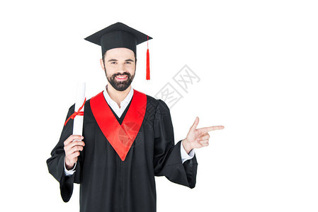 快乐的年轻学生持有毕业文凭用手指向白图片